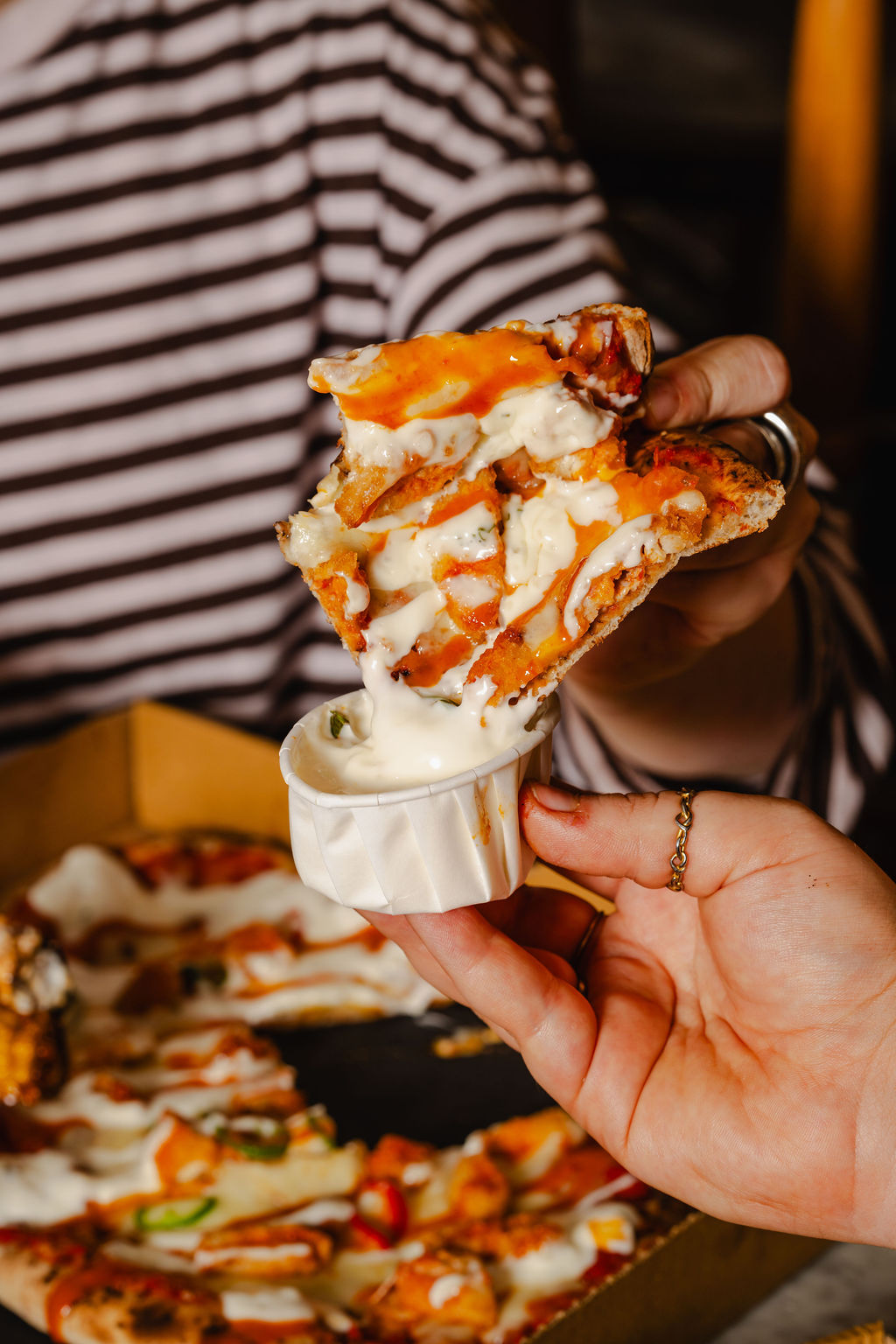 A Six Slice slice being dipped into sauce